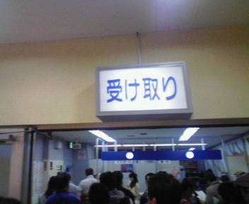「受け取り」と書かれた告知灯が着いている部屋。ごった返してます(パスポート受け取り)